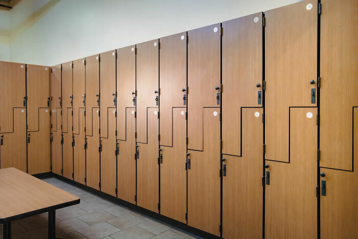 Locker room at Gold's Gym with wooden lockers and benches, relevant to backlash after lesbian confronted trans woman incident