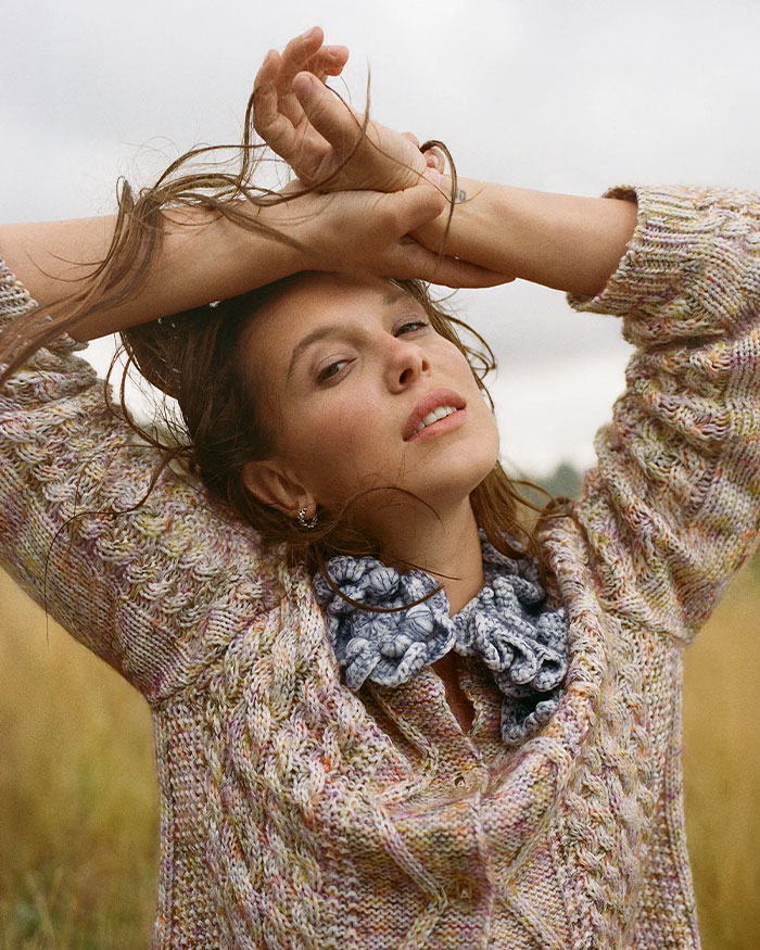 Millie Bobby Brown posing outdoors in a knitted sweater, addressing adopting a baby and criticism at age 21. Millie Bobby Brown posing outdoors in a knitted sweater, addressing adopting a baby and criticism at age 21.