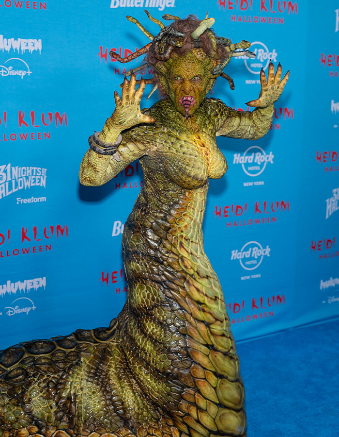 Celebrity in a detailed Medusa costume with snake scales and headpiece at a Halloween event, showing impressive Halloween costumes.