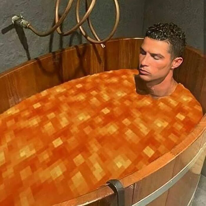 Man relaxing in a wooden tub filled with pixelated orange blocks in a creative and humorous pics that go hard image.