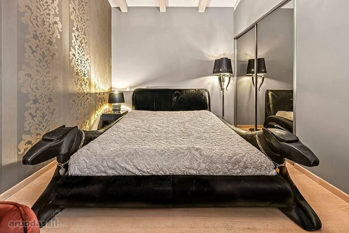Cama única en listado inmobiliario entretenido, diseño moderno con cabezas de animales y decoración elegante en habitación.