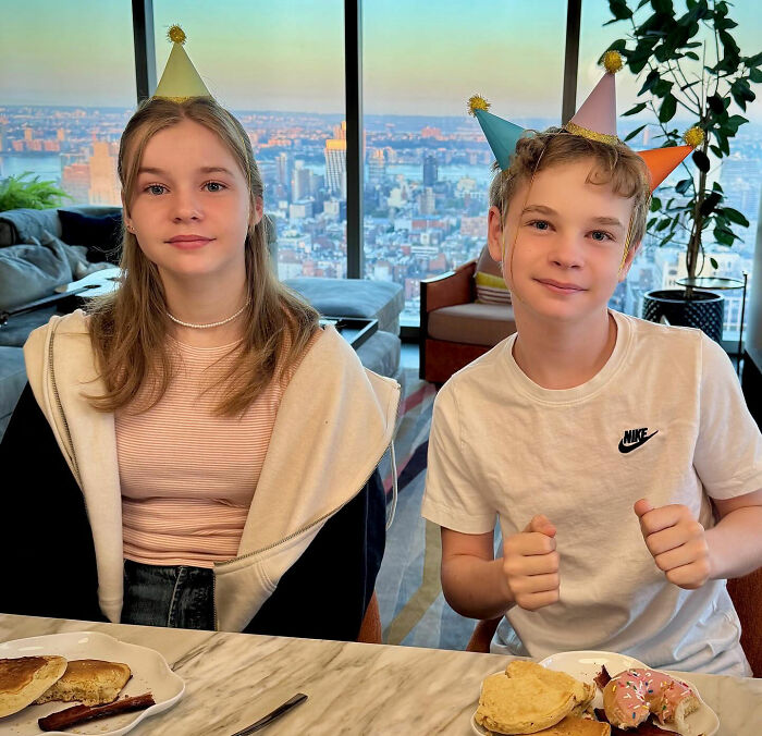 Teen girl with subtle makeup and long hair wearing a party hat, showcasing a grown-up look at a city view location.