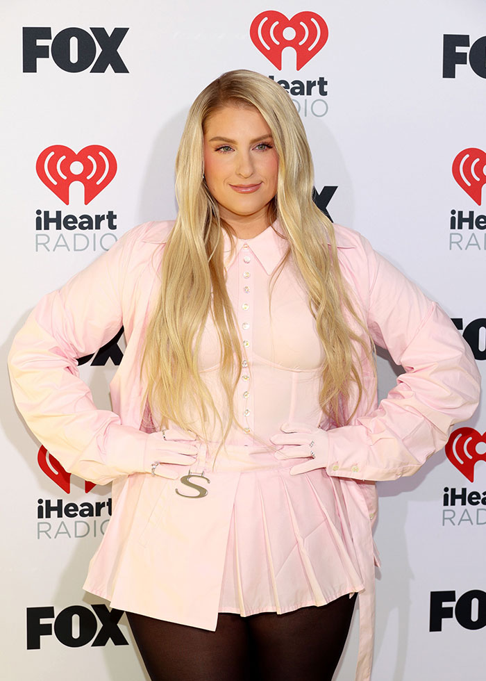 Meghan Trainor wearing a light pink outfit with long blonde hair at an iHeartRadio and FOX event.