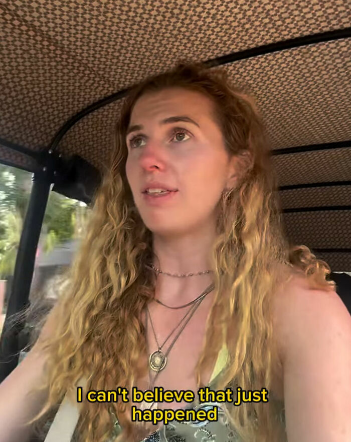 Woman with long curly hair revealing disturbing truth about solo traveling, looking concerned inside a vehicle.