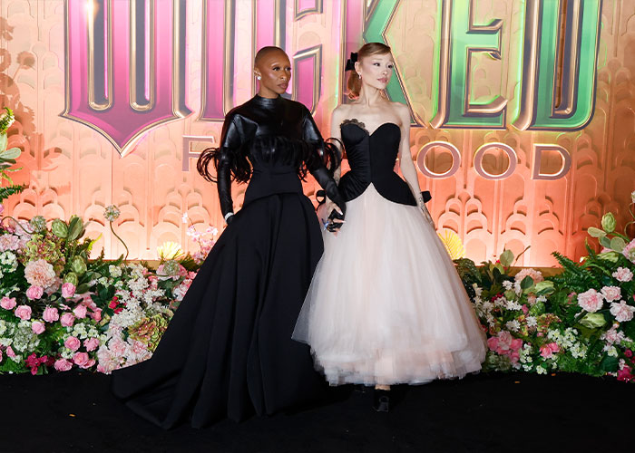 Ariana Grande and Cynthia Erivo posing together at an event, dressed in elegant black and white gowns.