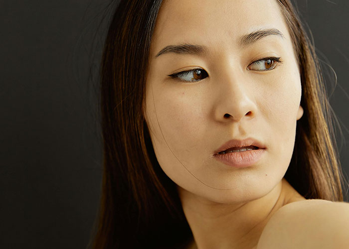 Young woman looking sideways with a concerned expression, illustrating reactions to bizarre events that creep people out.