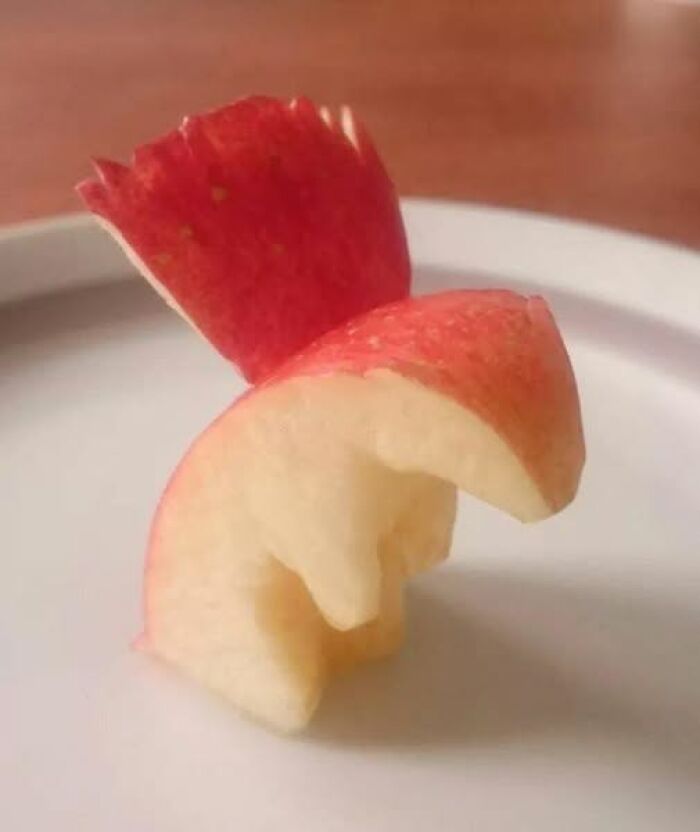 Creative apple carving resembling a bird with red peel wings, featured among pics that go hard and popular images.