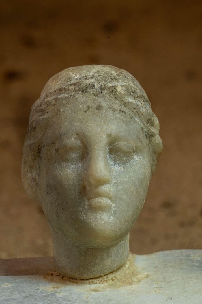 Ancient marble head sculpture with weathered features, an intriguing archeology find from around the world.