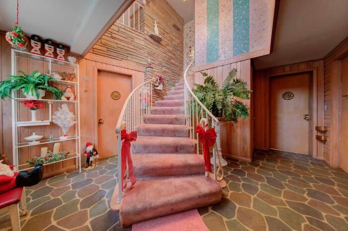 Interior view of a unique Zillow home featuring a carpeted staircase, holiday decor, and stone-patterned flooring.
