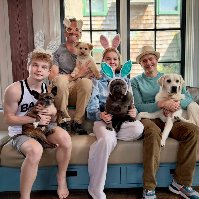 Neil Patrick Harris&rsquo; daughter Harper, 15, wearing bunny ears and holding a dog, sitting with family and pets indoors.