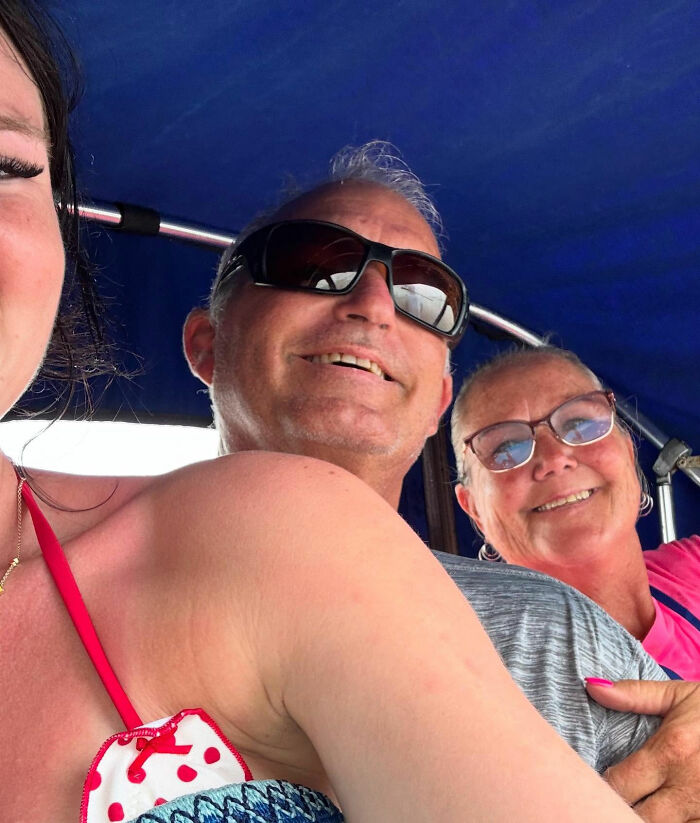 Three people smiling on a boat with a blue canopy, related to the grandma of teen whose body was found under cruise bed.
