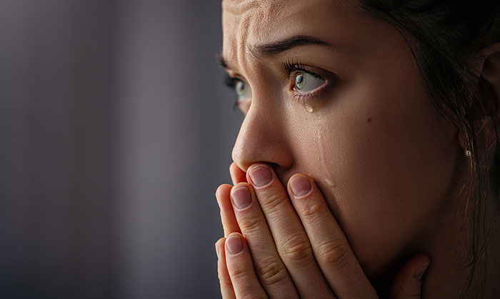 Close-up of a woman with tears in her eyes, reflecting the emotional reality of being a stay-at-home mom.