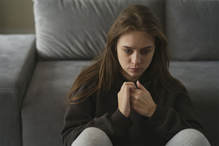 Teenage girl sitting alone looking worried, illustrating a mom preventing solicitor contacting daughter about inheritance. Teenage girl sitting alone looking worried, illustrating a mom preventing solicitor contacting daughter about inheritance.