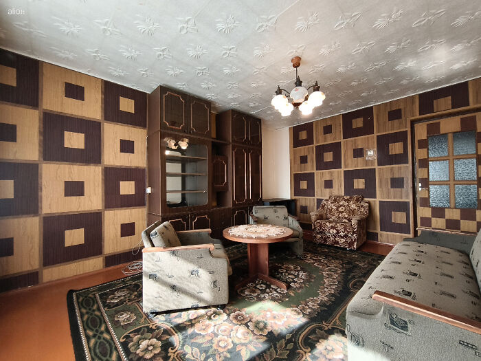 Vintage living room with wild real estate listings featuring unusual patterned walls and retro furniture.