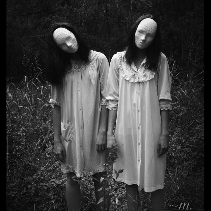 Two figures in vintage nightgowns with featureless faces standing in a dark forest, evoking scary games to play with friends.