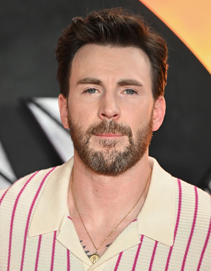Chris Evans close-up portrait with beard, wearing a striped shirt amid cheating rumors and viral scandalous blind items.