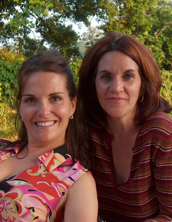 Two women smiling outdoors with greenery in the background, related to missing woman&rsquo;s body discovered in garage news.