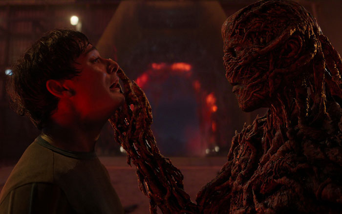 Stranger Things child actor facing criticism, a tense scene showing a close interaction with a monstrous creature in a dark setting. Stranger Things child actor facing criticism, a tense scene showing a close interaction with a monstrous creature in a dark setting.