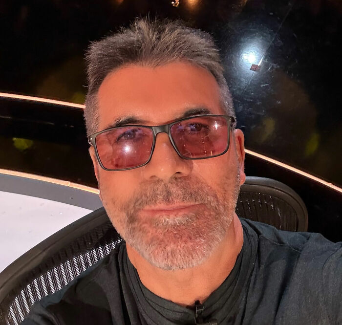 Simon Cowell wearing tinted glasses and a black shirt, addressing claims about Liam Payne's mental collapse in a close-up selfie.