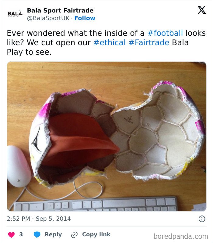 Cut open ethical Fairtrade football showing detailed inner structure and materials on a wooden table with keyboard nearby.