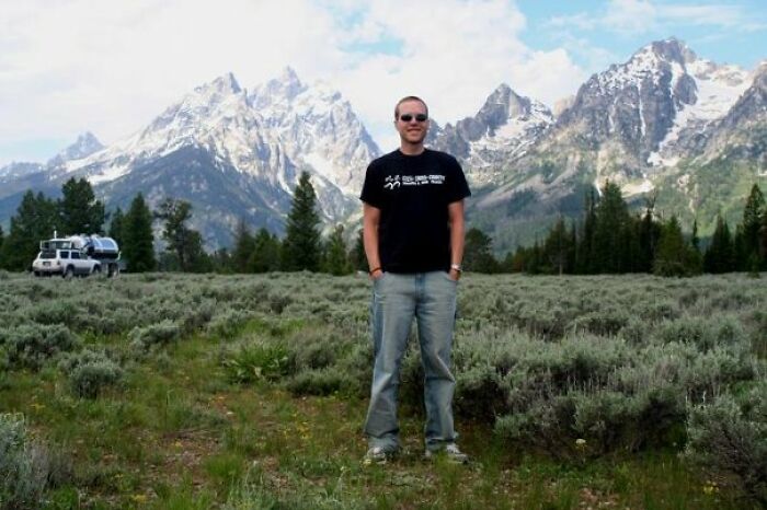 Man standing in a scenic mountain field representing a tragic father and son zip-lining incident during vacation.