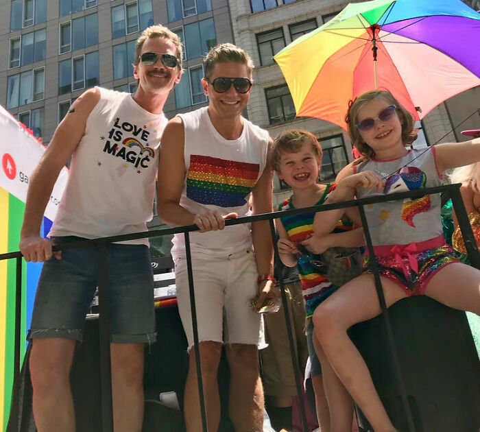 Neil Patrick Harris and family at outdoor event, with daughter Harper, 15, showing a grown-up look under a rainbow umbrella.