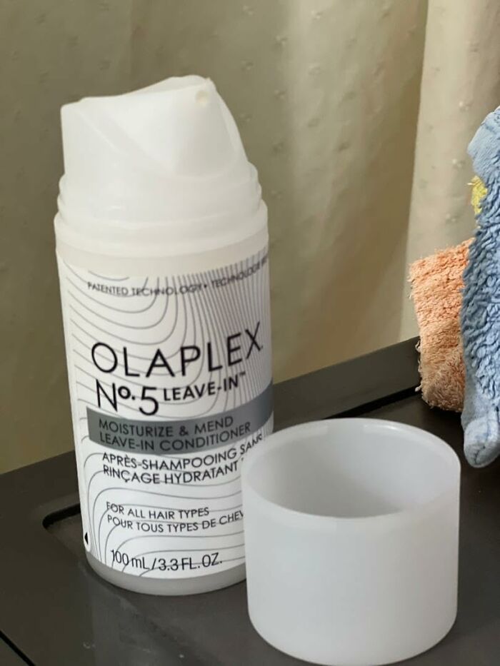 Olaplex No.5 leave-in conditioner bottle on a surface with towels nearby in a Cyber Monday deals setting.