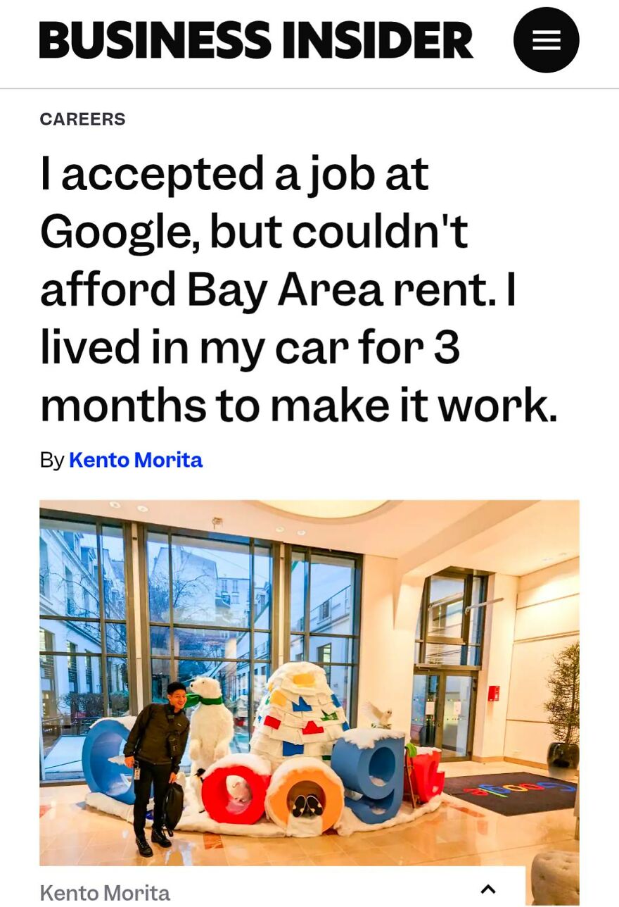 Person standing next to a Google logo sculpture with holiday decorations in a bright office lobby.