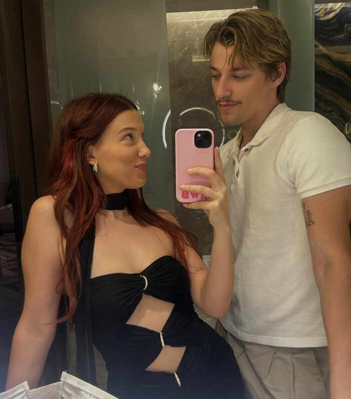 Millie Bobby Brown taking a mirror selfie with a man, both dressed casually, raising eyebrows with new photos. Millie Bobby Brown taking a mirror selfie with a man, both dressed casually, raising eyebrows with new photos.