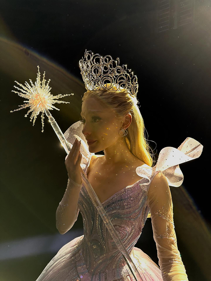 Woman in a sparkling princess dress and ornate crown holding a glowing wand, illustrating emotional age regression concept.