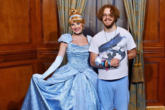 Man posing with a woman dressed as Cinderella, showcasing people turning their dreams into reality and inspiring the internet.