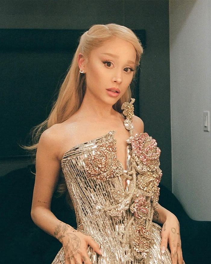 Ariana Grande posing in an ornate gold dress, sparking fan debates over specific type of plastic surgery in before-and-after shots.