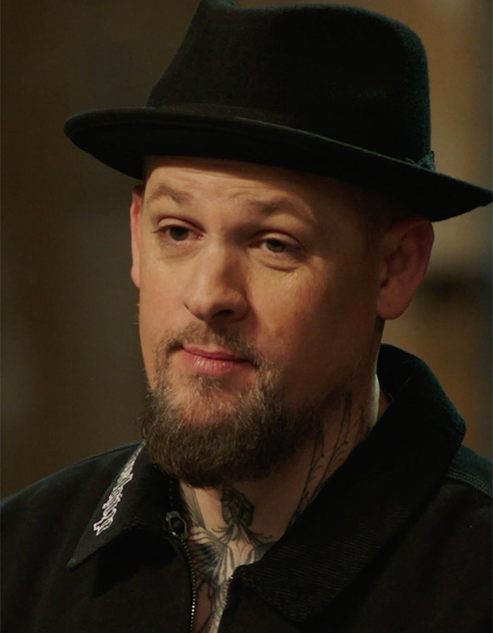 Man wearing a black hat and jacket with neck tattoos, related to Hilary Duff&rsquo;s 2000s age-gap relationship controversy.