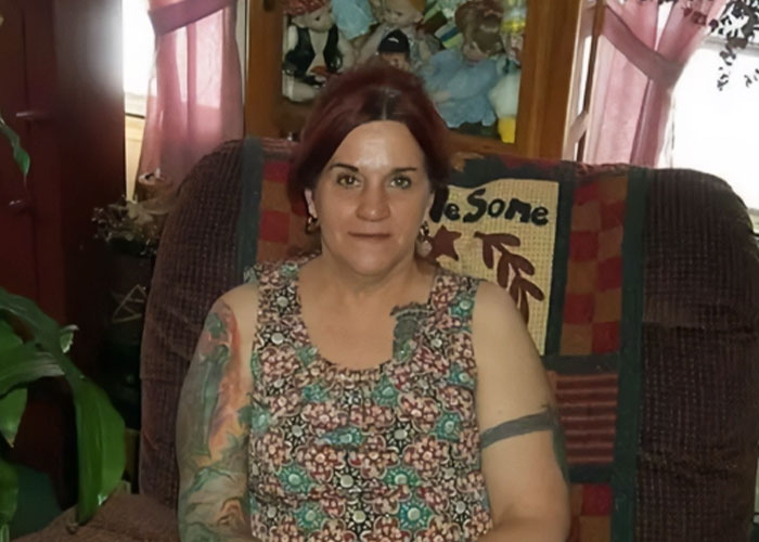 Woman with tattoos sitting on a chair indoors with plants and dolls in the background missing woman&rsquo;s body discovered in garage.