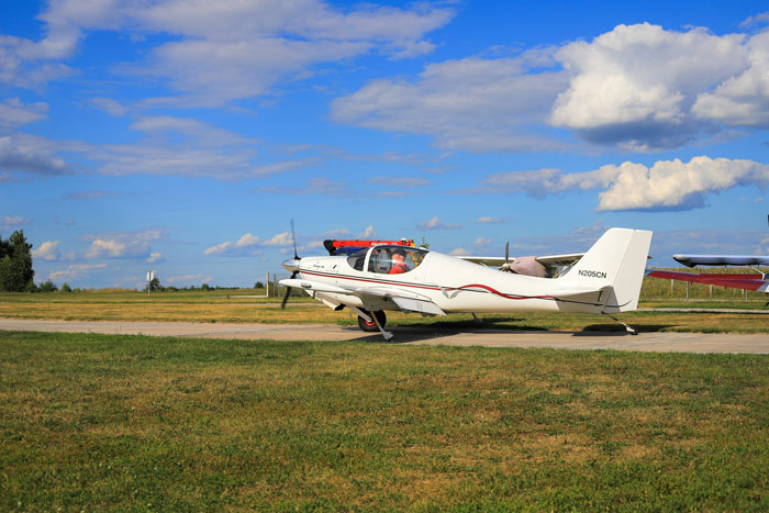Small white airplane on runway under blue sky, illustrating pilots' terrifying close calls mid-flight experiences.