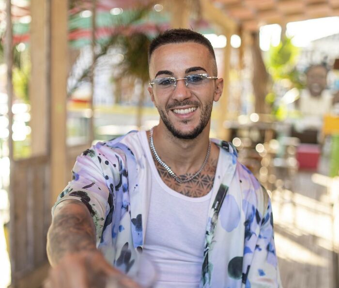 Young man smiling confidently in casual clothes revealing experiences of people who disappeared to start new lives