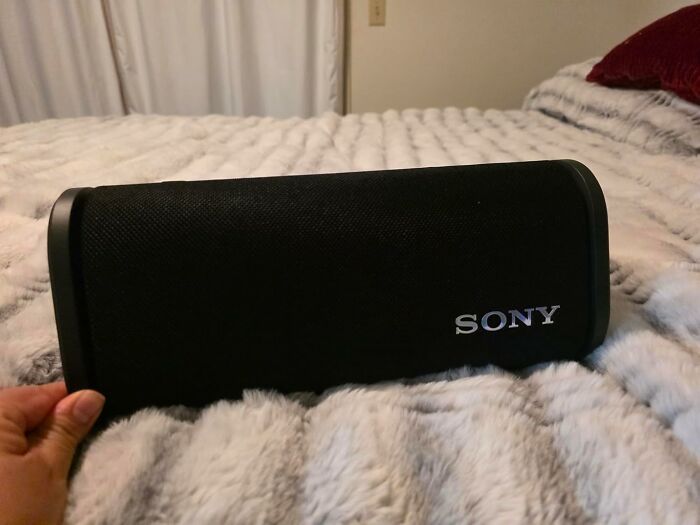 Black Sony portable speaker on a fuzzy blanket, highlighting popular tech deals for Cyber Monday weekend sales.