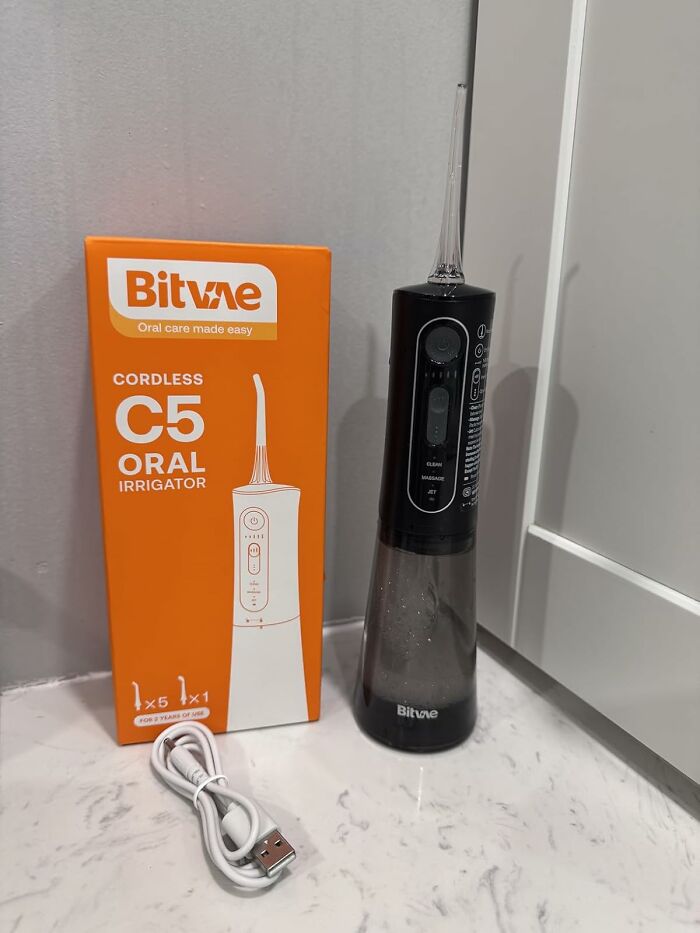 Bitvae cordless C5 oral irrigator with USB charging cable displayed on a countertop for 11.11 deals promotion.