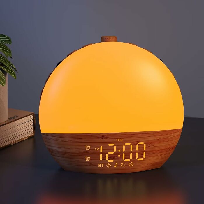 Warm glowing smart alarm clock on wooden base, a cozy find to make your house feel inviting and comfortable.