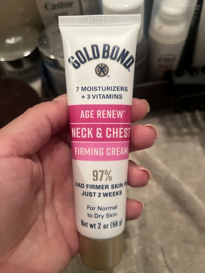 Hand holding Gold Bond Age Renew Neck & Chest Firming Cream, a popular beauty product for firmer skin and vanity restocking.