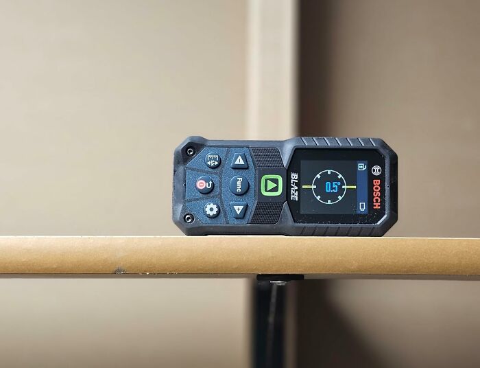 Bosch laser distance measurer on a wooden surface showcasing tech gadgets in Cyber Monday weekend deals.