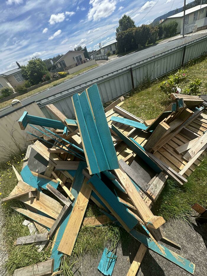 Broken wooden outdoor furniture scattered messily on grass, showing family frustration moments shared online.