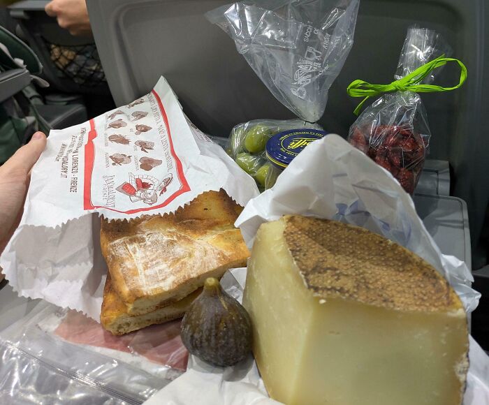 Snack tray with bread, cheese, fig, olives, and dried fruit, showcasing iconic girl dinner combos on a tray table.