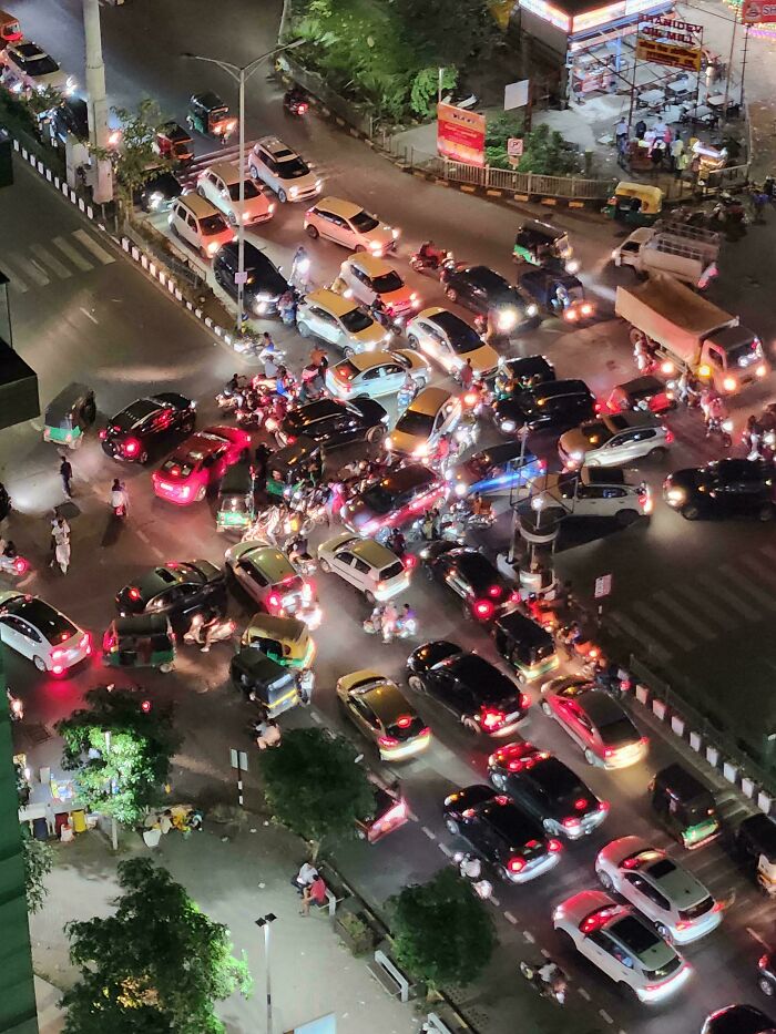 Chaotic traffic jam with cars and motorcycles blocking an intersection, showing a lack of common sense and road rules.