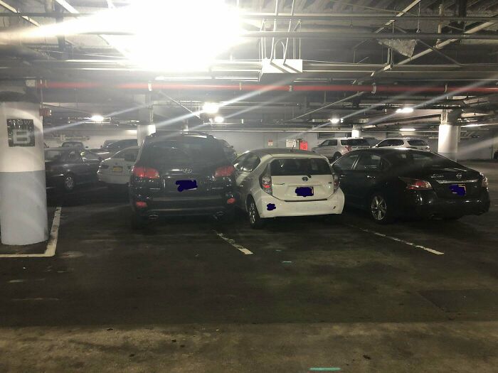 Cars poorly parked in an underground garage, showing lack of common sense and confusing parking spaces.