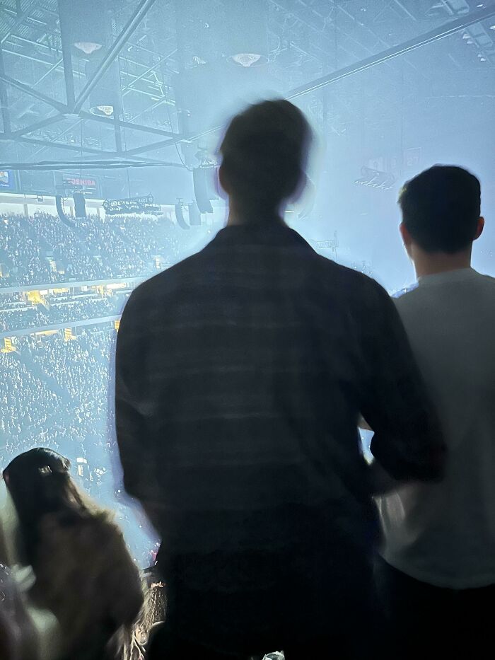 Two people standing at a crowded event, highlighting a moment of zero common sense in a large audience setting.