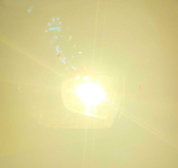 Bright sunlight reflecting off a mirror causing intense glare, illustrating a lack of common sense in handling light.