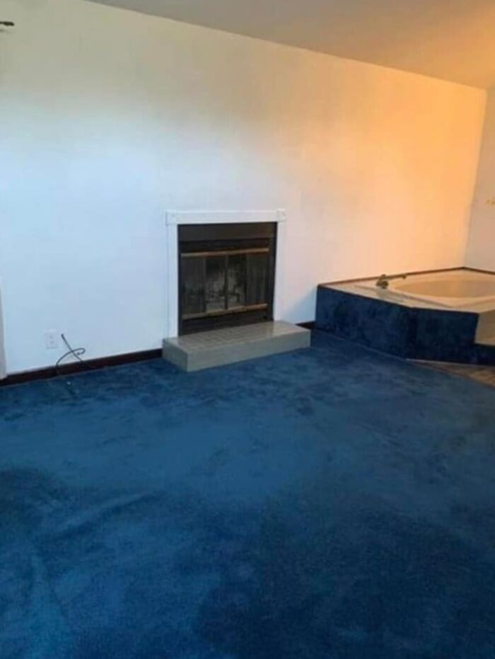 Room with blue carpet near a fireplace and a built-in bathtub, part of unusual Zillow homes to see and believe.