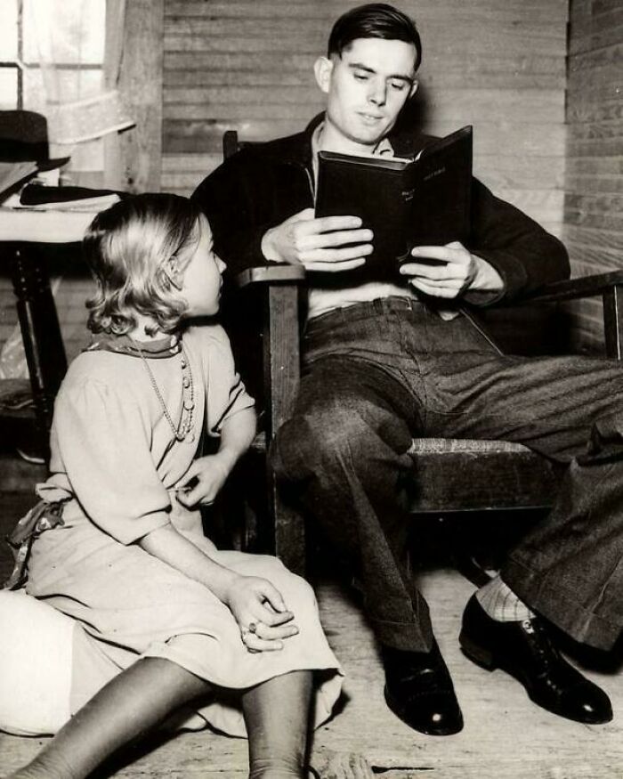 Black and white historical photo of a man reading to a young girl, capturing a unique moment with a deep backstory.