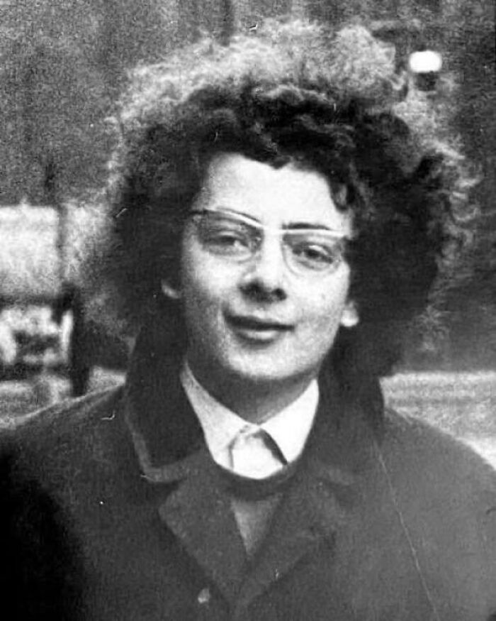 Black and white historical photo of a young person with glasses and curly hair, showcasing unique historical moments.